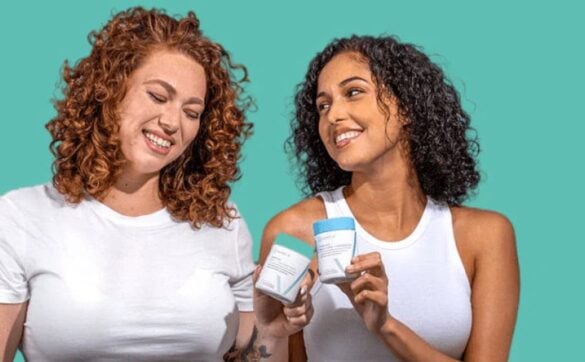 Two women holding Happy V wellness products