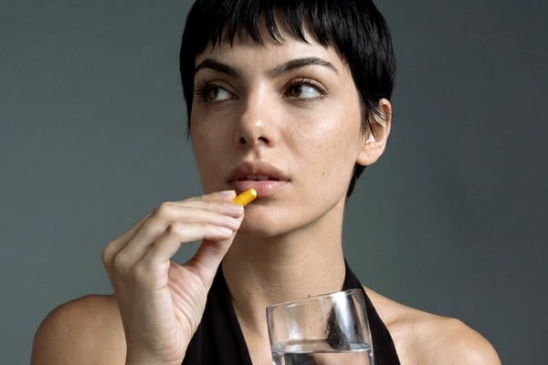 Mujer tomando una cápsula de Aldous Bio