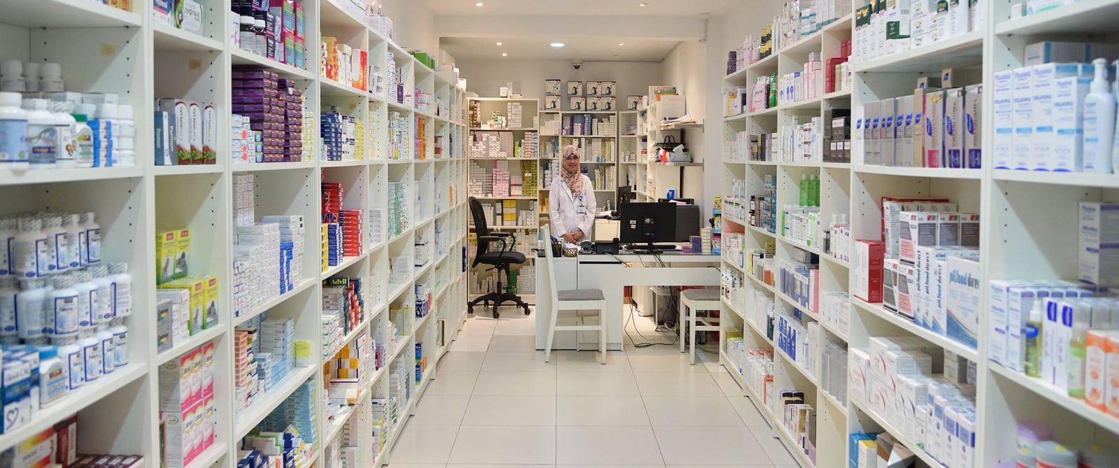Farmacista davanti agli scaffali di una farmacia