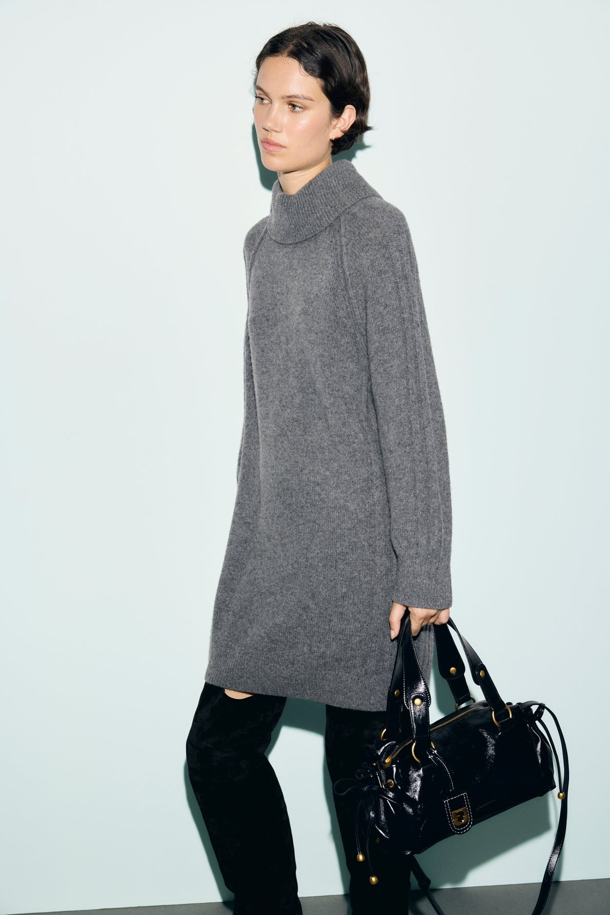 Robe en maille grise portée avec des bottes noires
