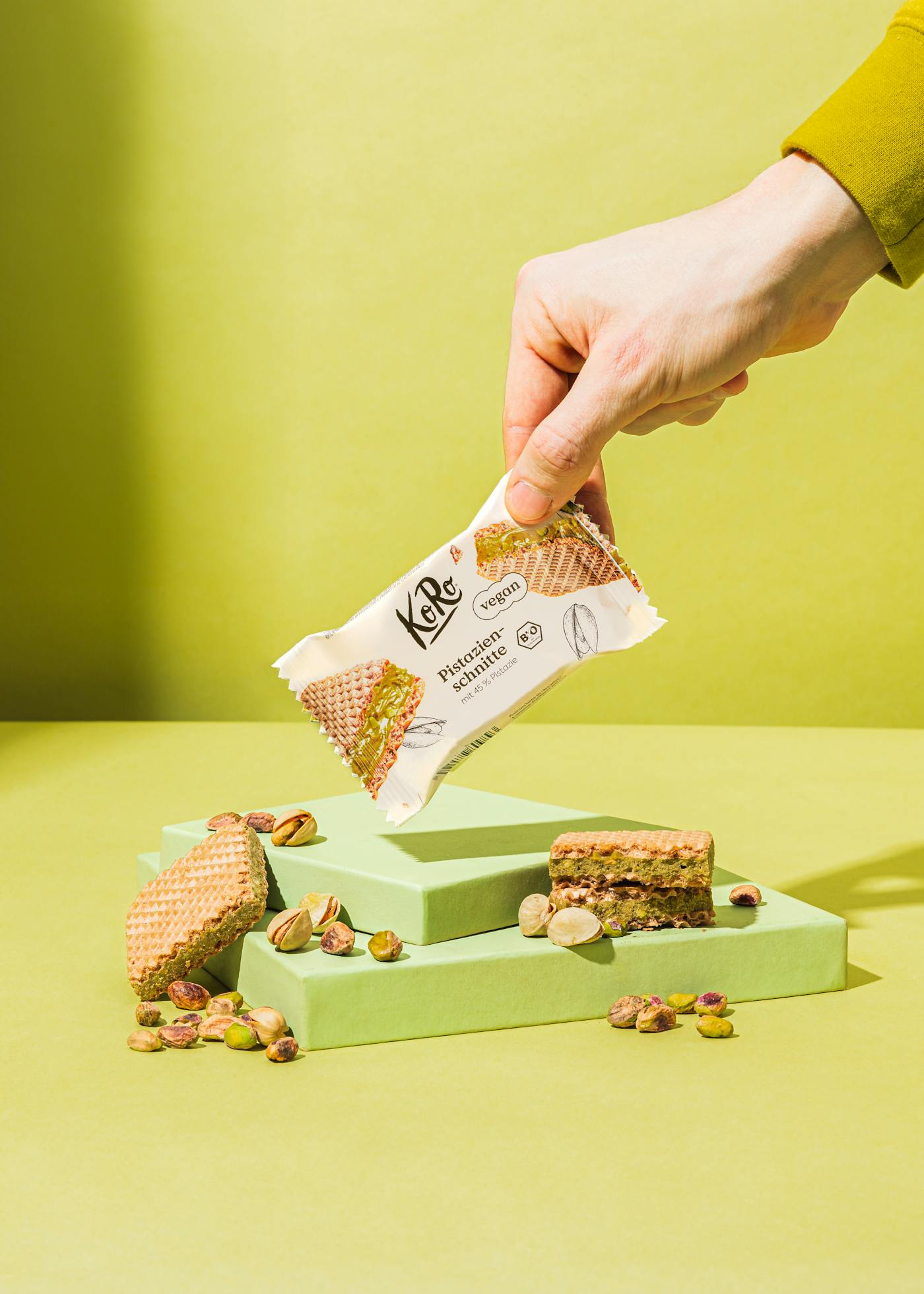 Eine Hand hält eine Pistazienschnitte
