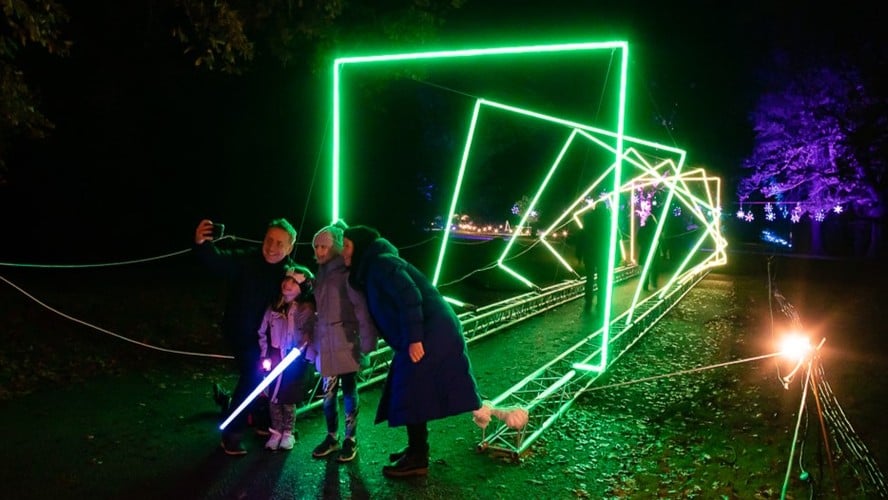 Visitors among glowing installations at a Colchester light trail