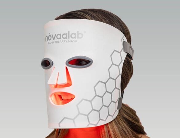 A person using red light therapy on the face