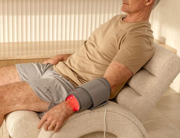 A person using a red light therapy pad
