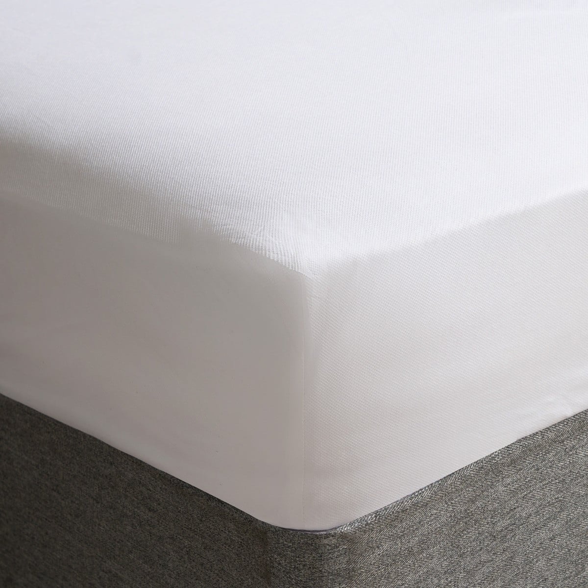 White waterproof mattress protector shown fitted on a mattress