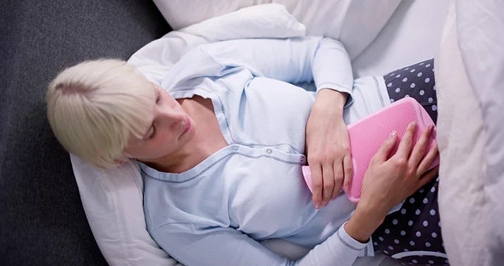 Woman holding a hot water bottle