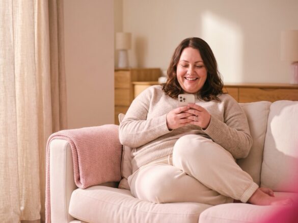 Woman relaxing at home while looking at her phone