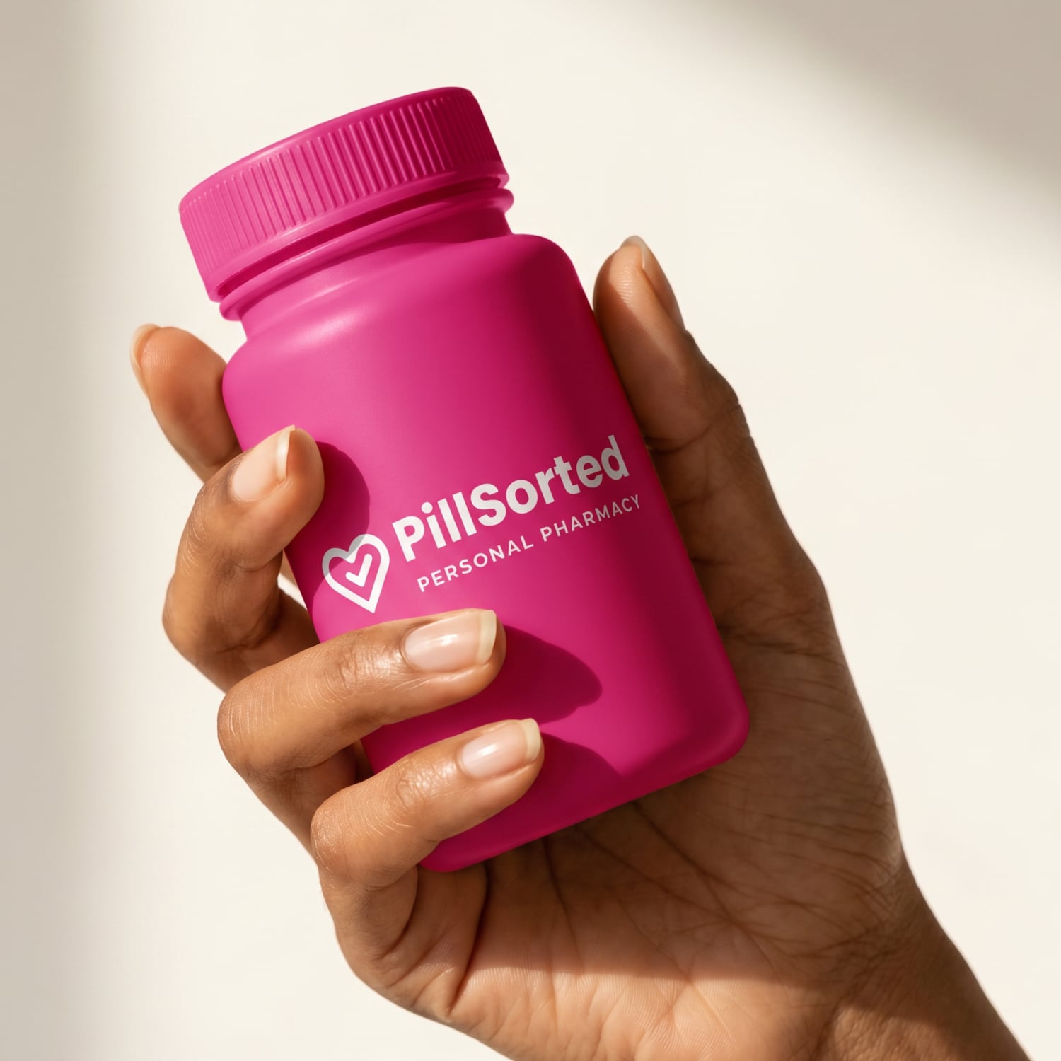 Hand holding a pink tablet bottle