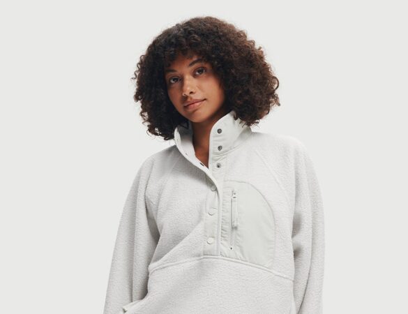 Model wearing a bone-colored Fleece Quarter Button Pullover with dark pants